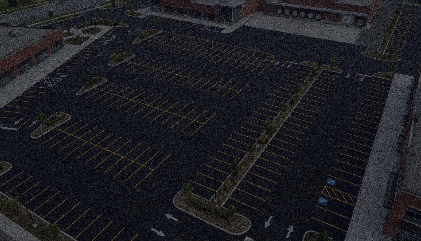 Freshly painted parking lot line markings on dark asphalt