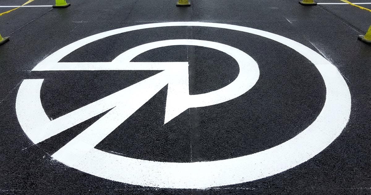 Custom pavement stencil marking with directional arrow on asphalt
